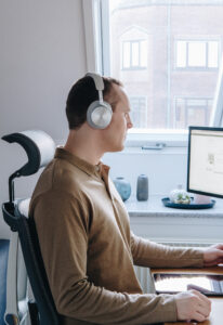 person sitting in front of computer with headphones